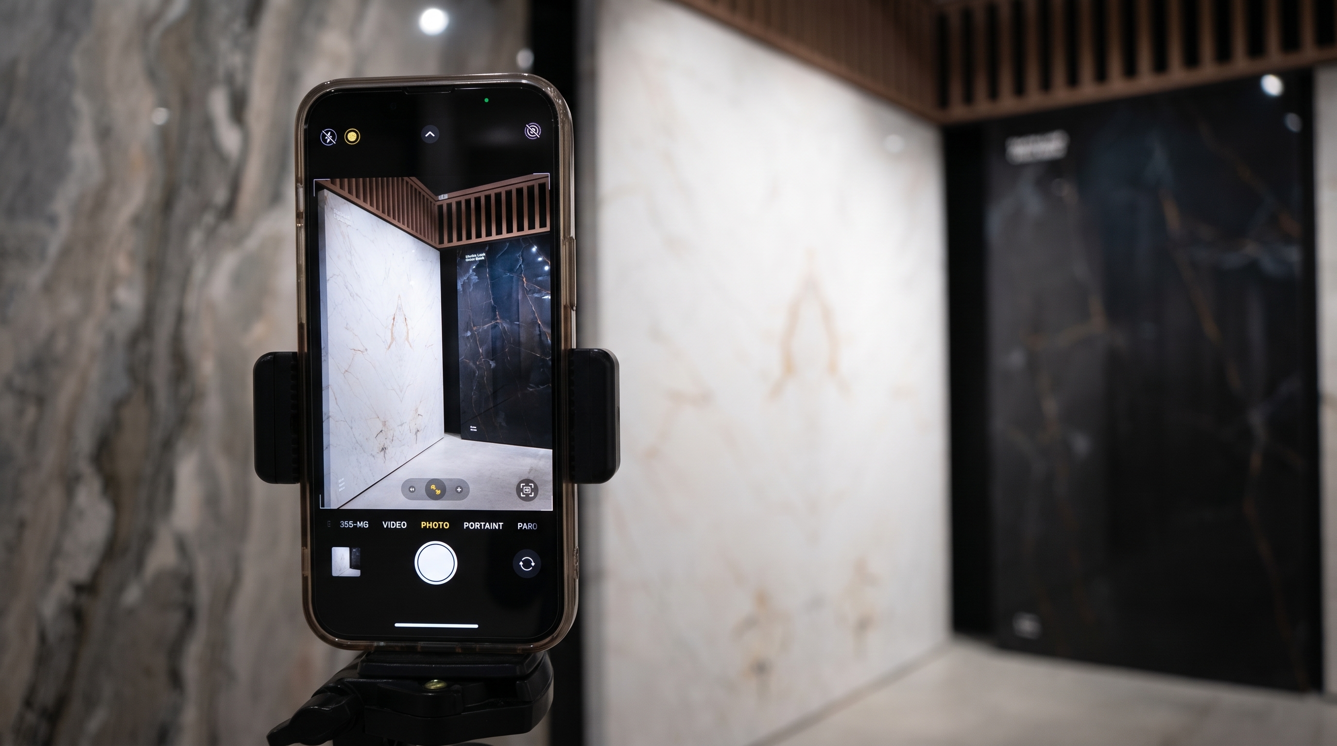 a phone on a tr-pod with camera active in a stone showroom focus on slabs